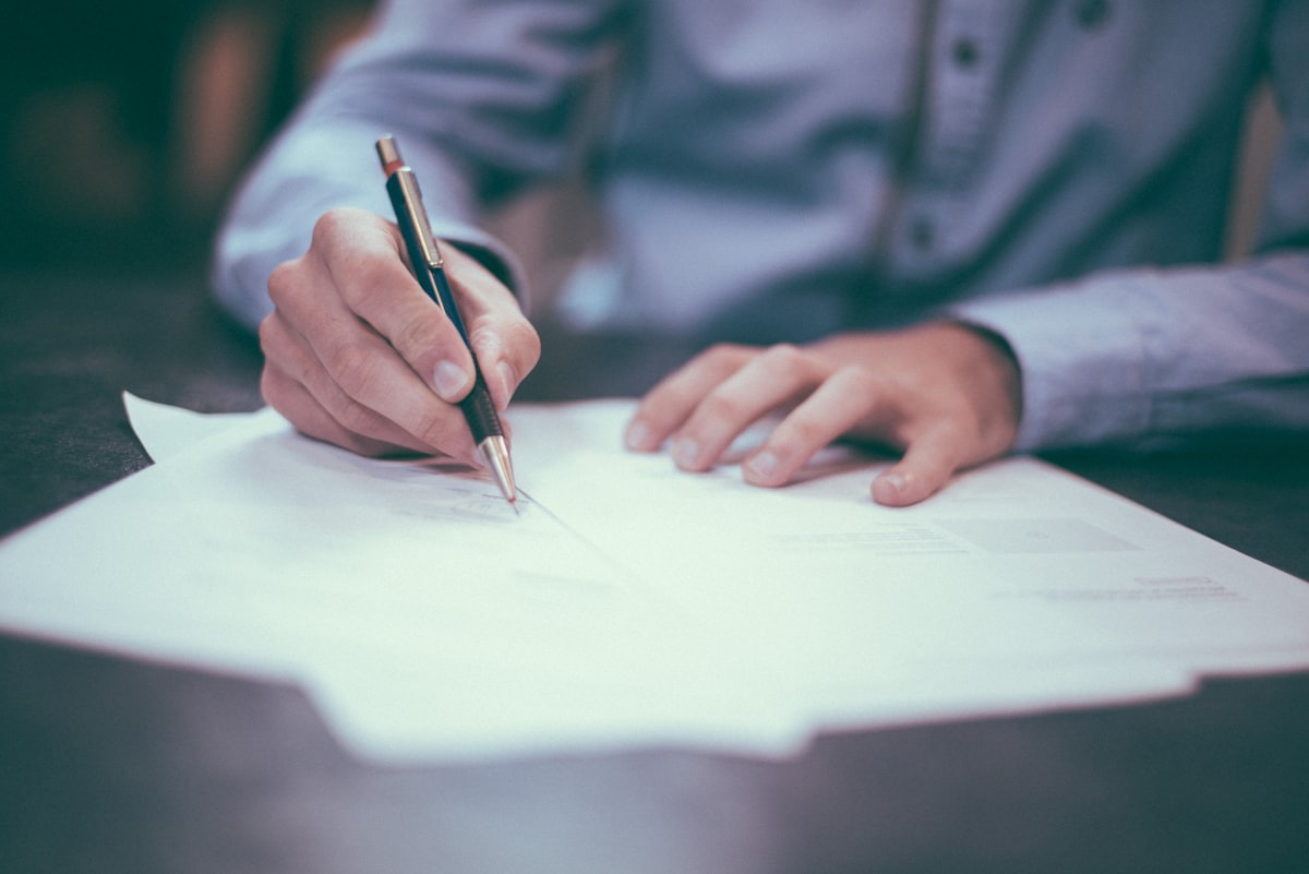 Profissional analisando documentos e prazos em mesa de trabalho